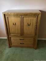 Front view of the Holland highboy cabinet showing two upper doors and two drawers below with brass recessed handles.