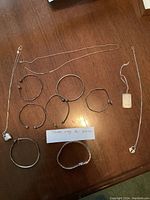 Overview of all necklaces and bracelets laid out on wood surface