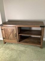 Photo of the TV stand showing front closed view with two open shelves and one door on left side.