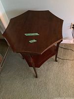 Top angled view of the octagonal wood end table showing the inlaid decorative border and visible finish condition.