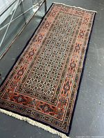 Full length view of rectangular handmade rug showing overall pattern and fringe