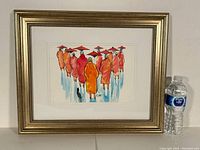 Full view of framed watercolour painting showing monks walking with parasols; a water bottle placed nearby for scale.