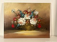 Full view of the oil painting showing a basket filled with vibrant floral arrangement and the artist's signature.