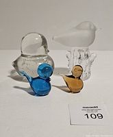 Front view of four art glass birds displaying colors and details