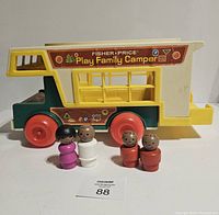 Side view of Fisher Price Play Family Camper with four wooden peg family figures standing in front.