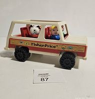 Side view of Fisher Price Station Wagon toy with three figures inside shown clearly
