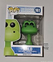 Front view of Funko Pop box with green Arlo dinosaur figure inside, labeled number 161 from The Good Dinosaur series.