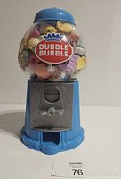 Front view of the blue Original Dubble Bubble gumball machine with clear globe full of colorful Shopkins toys inside.