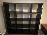 Front view of the black IKEA Billy bookshelf with 16 square compartments, showing overall condition and design.