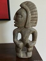 Front view of soapstone tribal figure showing headdress and stance