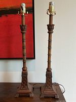Full view of the pair of antique style carved wood lamps, showing their height and overall design with socket included
