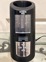 Front view of black Waring Pro wine chiller and warmer showing control panel and temperature display window.