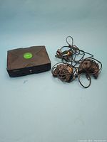 Xbox console, two controllers, and cables on blue background