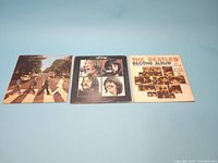 Photo showing all three vinyl record covers laid flat: Abbey Road, Let It Be, The Beatles' Second Album