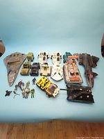 Complete layout showing 3.75 inch scale G.I. Joe figures and vehicles including tanks, aircraft, and an aircraft carrier along with incomplete figures.