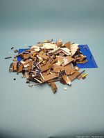 Overview pile of tan, white, dark bluish gray LEGO pieces and two blue baseplates on light blue background