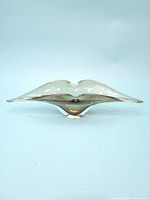 Front view of smokey art glass console bowl showing the curved, waved edges and overall organic form.