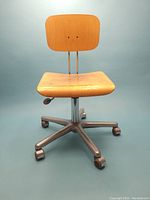 Front view showing plywood seat and back with metal wheeled base.