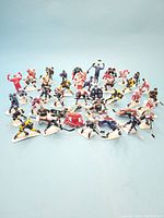 Wide view showing entire lot of 44 NHL Starting Line Up hockey player action figures posed on a light blue surface.