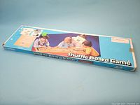 Box of Carrom Shuffle Board Game with image of children playing and branding