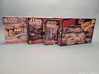 Four Star Wars AMT model kits boxes, showing front artwork and titles: Battle of Hoth Action Scene, two Cantina Action Scene kits, and Empire Strikes Back Rebel Base. Boxes approx. 13"x19".