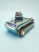 Side angle view showing the body and turret details of the vintage space tank tin toy.