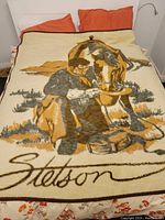 Cream-colored vintage Stetson blanket showing cowboy feeding horse and Stetson name