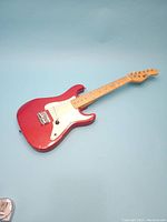 Full view of the youth electric guitar showing body and fretboard on a blue background.