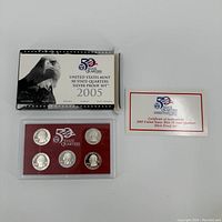 2005 United States Mint State Quarters Silver Proof Set with original box, protective coin holder containing five quarters, and certificate of authenticity.