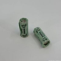 Two green Harrah's Casino paper rolls standing and lying on white background