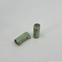 Two green paper-wrapped dime rolls on white surface