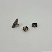 Group view of three sterling silver rings with marcasite and pink stone accents