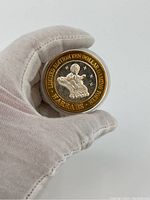 Obverse side of the coin showing a sultan on a magic carpet with the inscription surrounding the design.