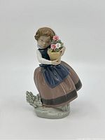 Front view of the Lladro porcelain figurine showing the girl holding the flowerpot with flowers.