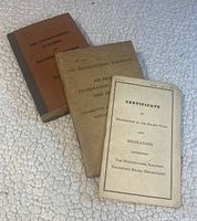 Front cover view of three vintage railroad-themed pamphlets including a 1942 Pennsylvania Railroad certificate, an air conditioning instruction booklet, and an air brake examination instruction booklet.
