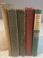 Five vintage hardcover books lined up vertically showing covers and spines for identification and condition assessment.