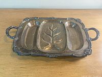 Front view of vintage large silver plated meat platter with three sections and two handles