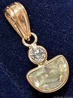 Front view of pendant showing round and half-moon stones against black background