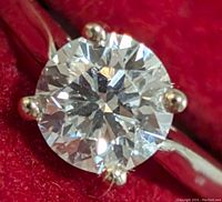 Close-up view of round brilliant diamond from top showing facets and prongs