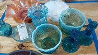 Overview of lot showing multiple carnival glass and blue glassware pieces including bowls, vases, and candlesticks
