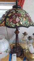 Full view of stained glass floral lamp with metal base and pull chain