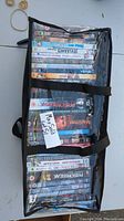 Top view of the carrying bag showing multiple DVD cases stacked inside with the bag partially unzipped.
