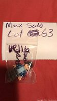 Photo shows a Lego minifigure resembling Harry Potter in a small plastic bag with 'Max Sold Lot 63' handwritten on paper behind.
