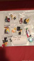 Ten assorted LEGO minifigures in individual plastic bags with accessories and note showing MaxSold Lot 89