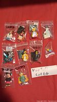 10 Lego minifigures in individual plastic bags on red background, including Disney princess, knights, Mickey Mouse, and other characters.