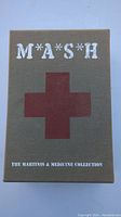 Front view of the M*A*S*H DVD box set with title, red cross, and collection name visible.