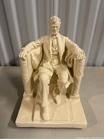 Side angled view of Abraham Lincoln figure statue seating on detailed chair.