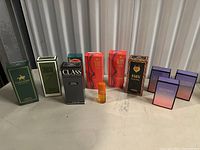 Wide shot of all nine cologne/perfume items in original boxes except one vial outside box.