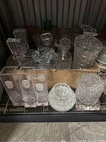 Photo of the large collection of various crystal items including vases, bowls, decanters and decorative pieces.