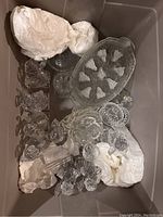 Overview photo of large crystal lot showing multiple pieces including bowls, figurines, and serving dishes packed with tissue paper.